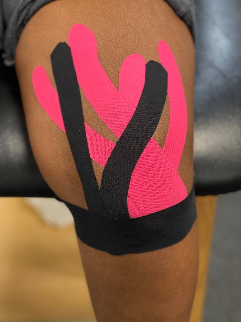Back in the Game patient enjoying the benefits of kinesiology tape, they are wearing hot pink and black tapes