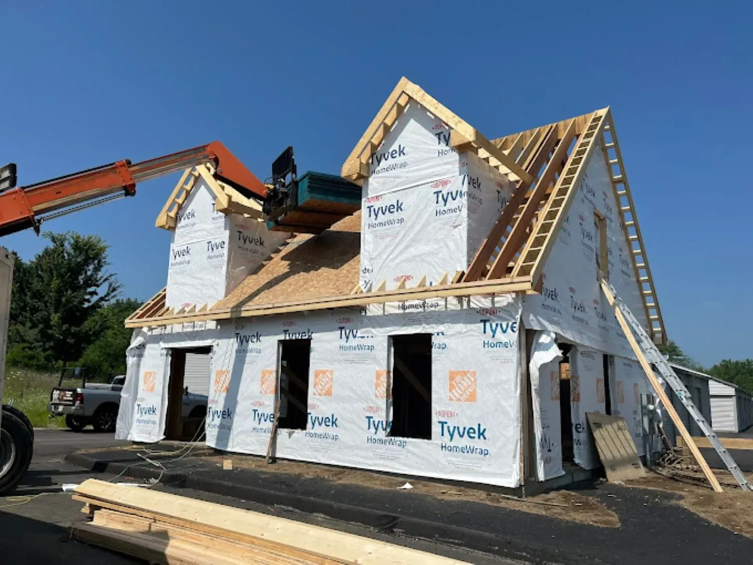 A house is being built with a crane on top of it.
