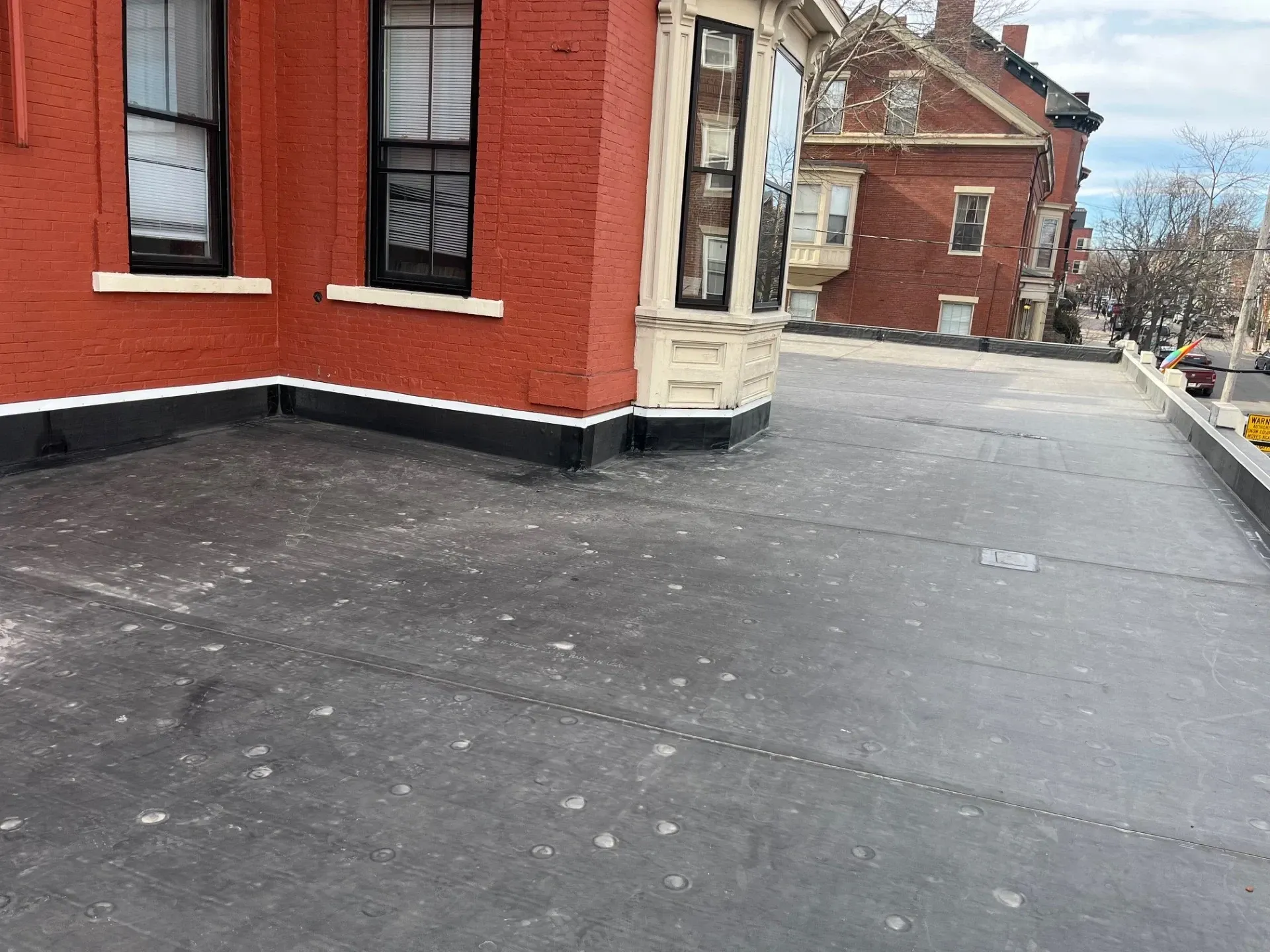 A large red brick building with a black roof