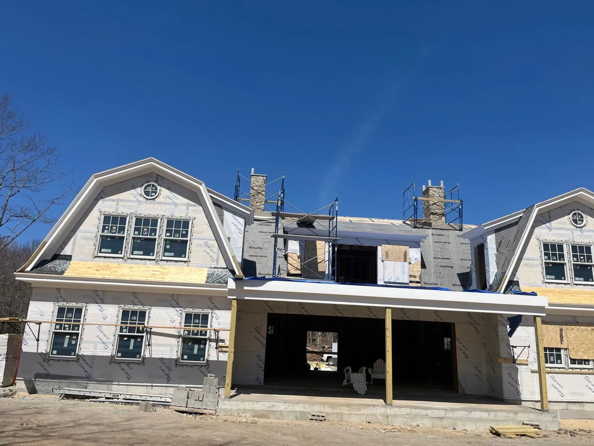 A large house under construction with a blue sky in the background.