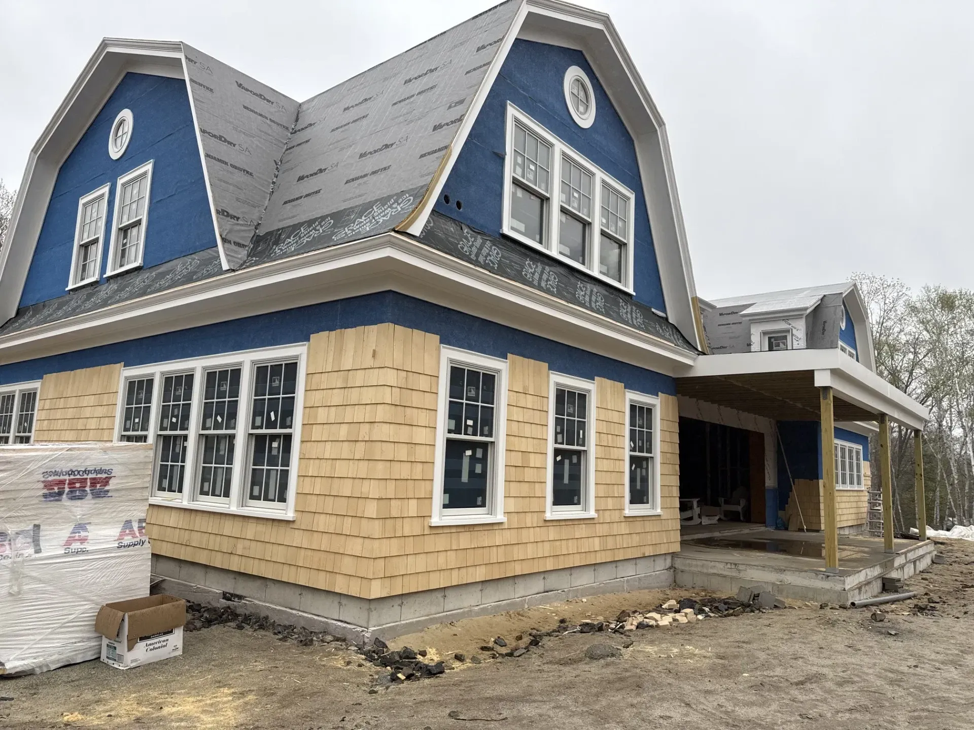 A house is being built with a blue roof and yellow siding.