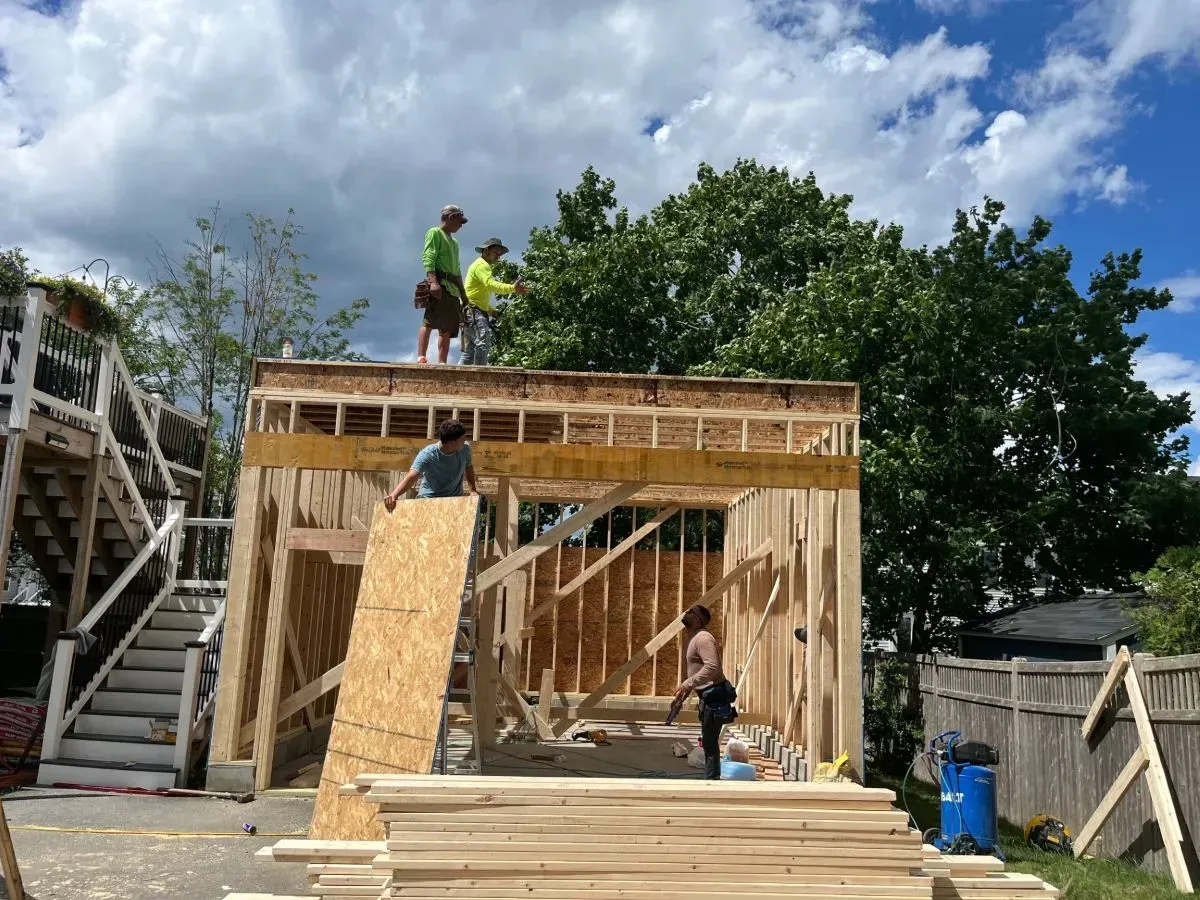 A group of people are standing on top of a wooden structure.