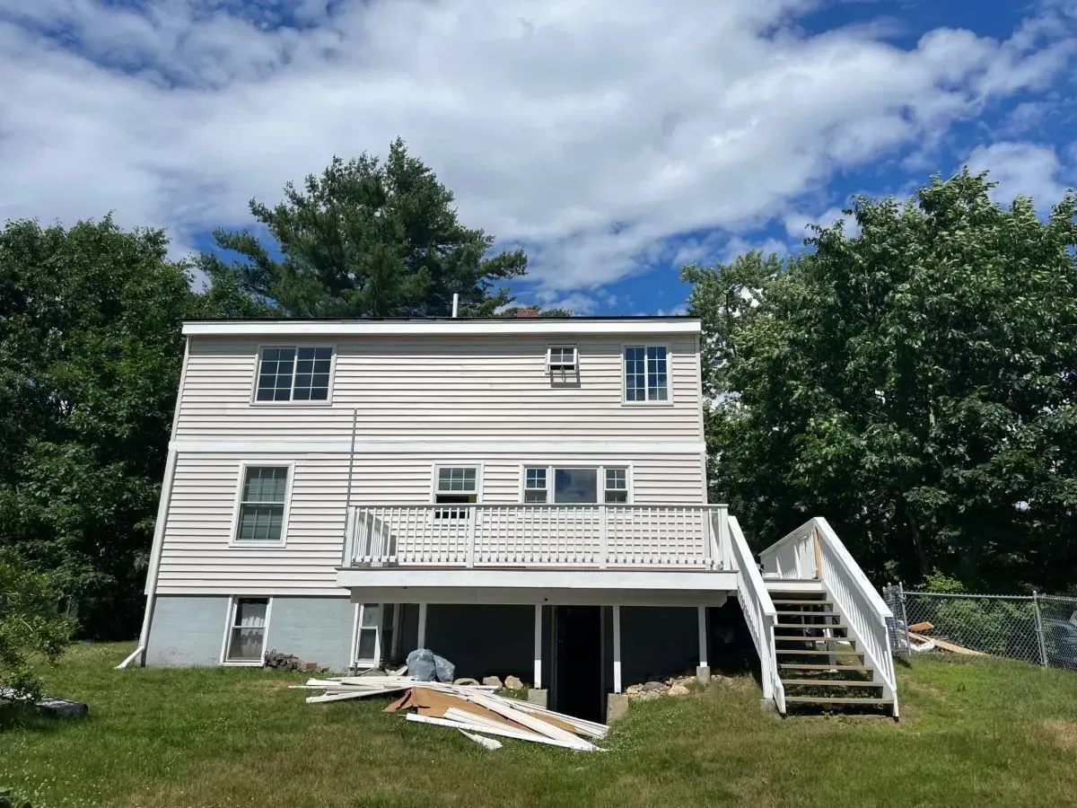 The back of a house with a large deck and stairs.
