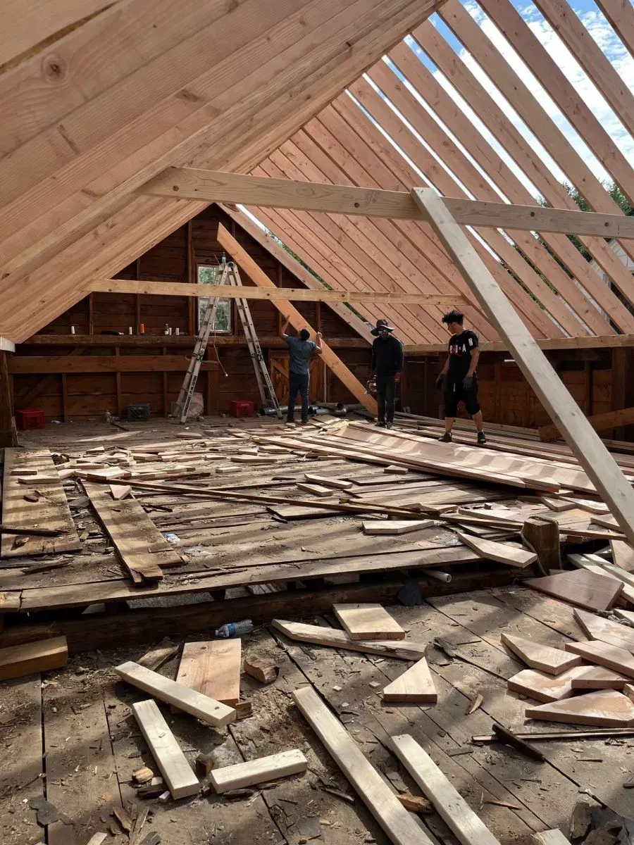 A group of people are working on the roof of a building.