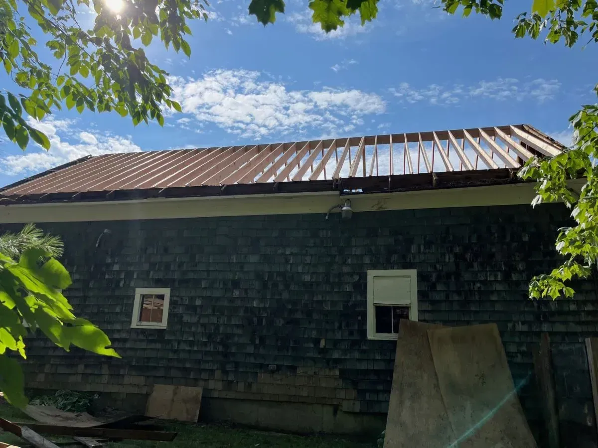 A house with a roof that is being built on a sunny day.