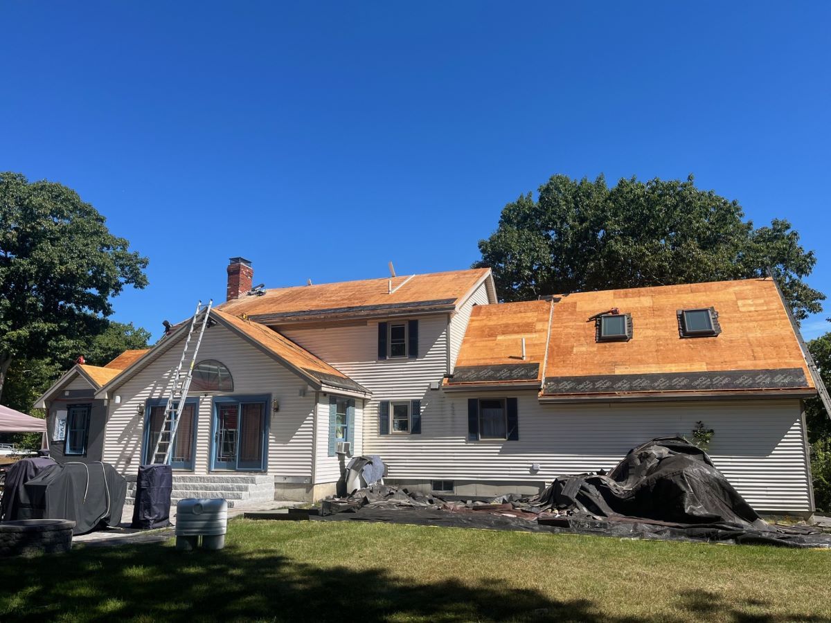 A large white house with a wooden roof is being remodeled.