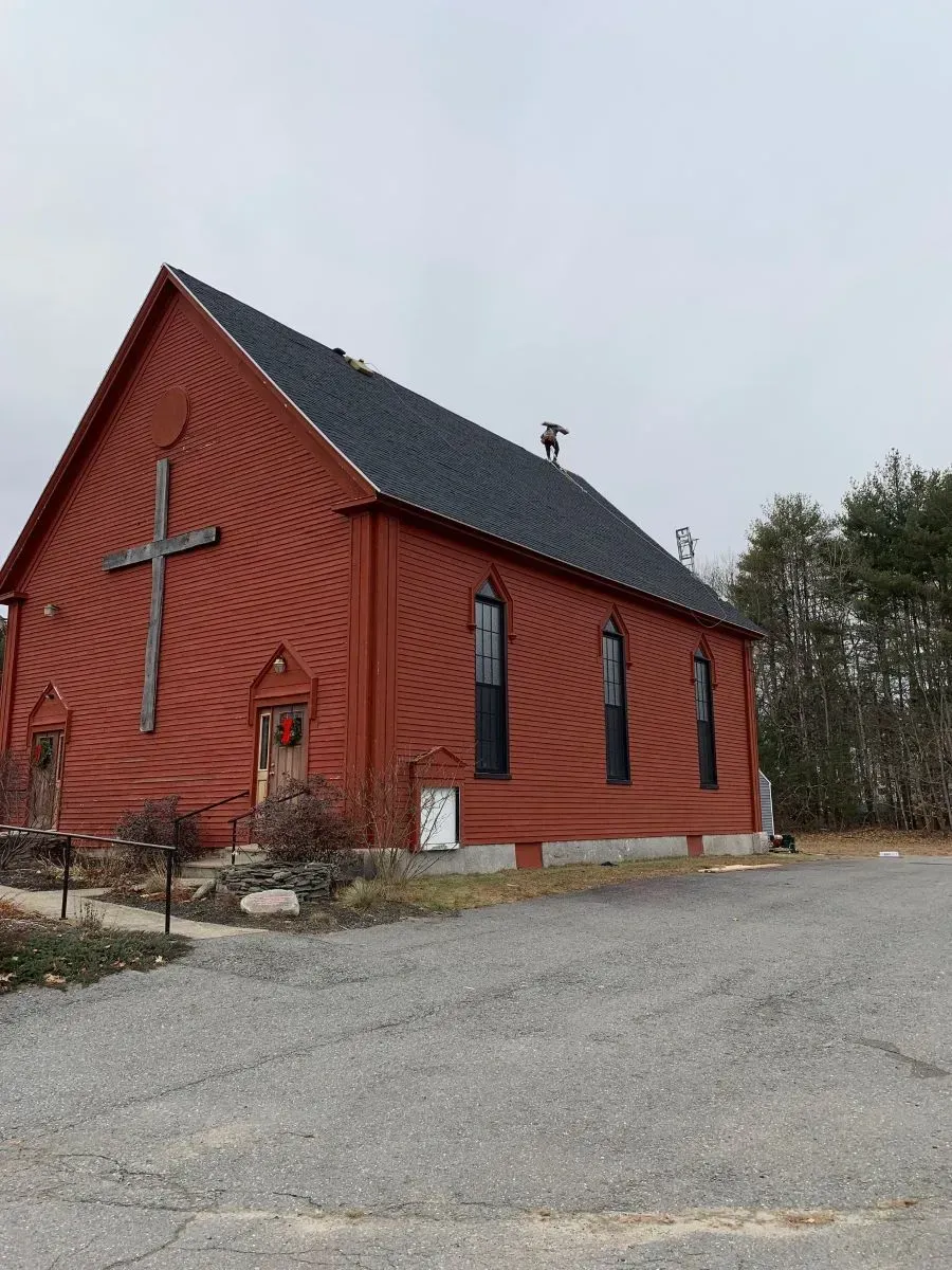 A red church with a cross on the side of it