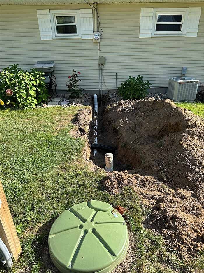 A septic tank is being installed in the backyard of a house.