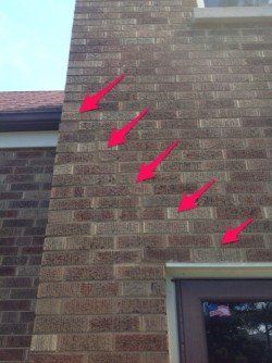 A close up of a brick wall with red arrows pointing to different bricks.