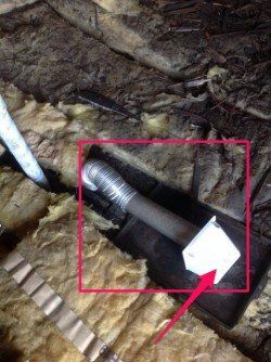 A close up of a pipe in a room with a red arrow pointing to it.