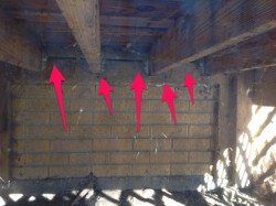 A brick wall with red arrows pointing in different directions.