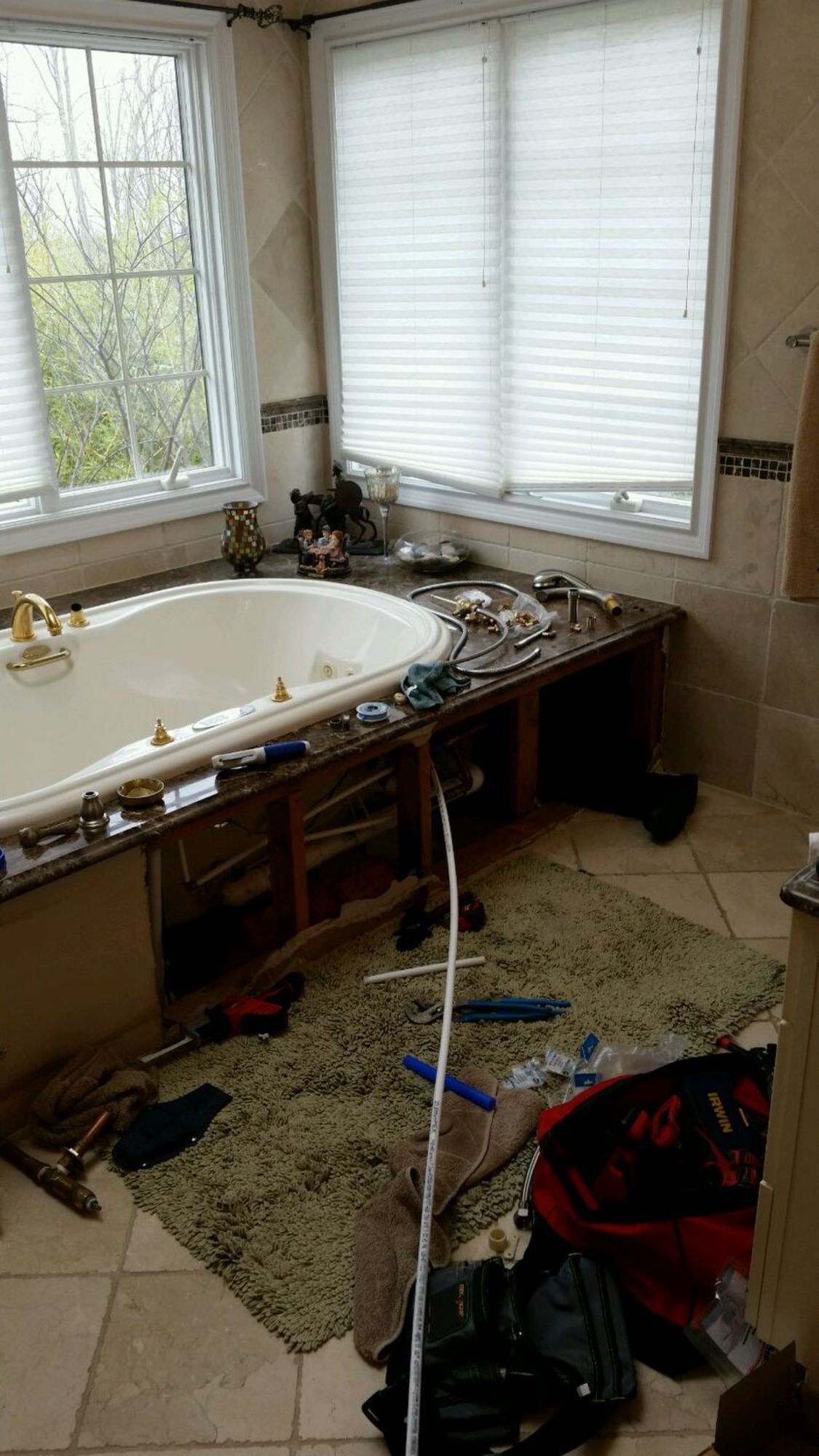 a bathroom with a jacuzzi tub and a lot of tools on the floor .
