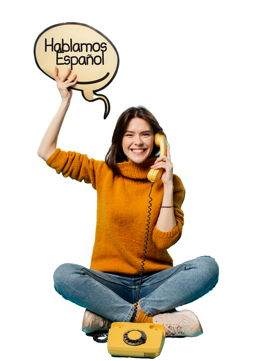 A woman is sitting on the floor talking on a yellow telephone.