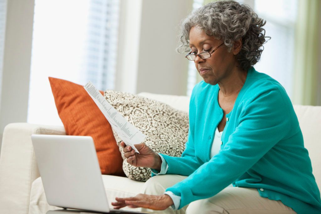 Woman in her 60s reviewing Medicare enrollment options at home 
