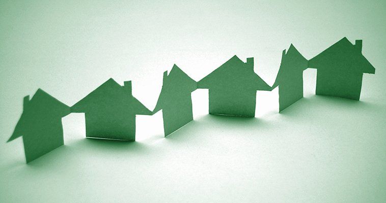 A string of houses cut out from green paper