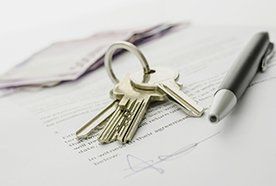 A set of keys and a pen on top of a signed document