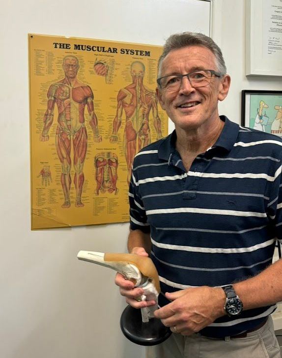 A man is getting his knee examined by a nurse.