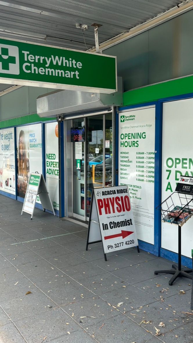 A man in a striped shirt is holding a model of a knee joint.
