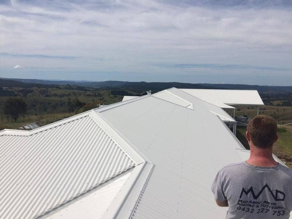 Man On Top Of White Roof — Mad About Metal Roofing & Guttering PTY LTD in Newcastle, NSW