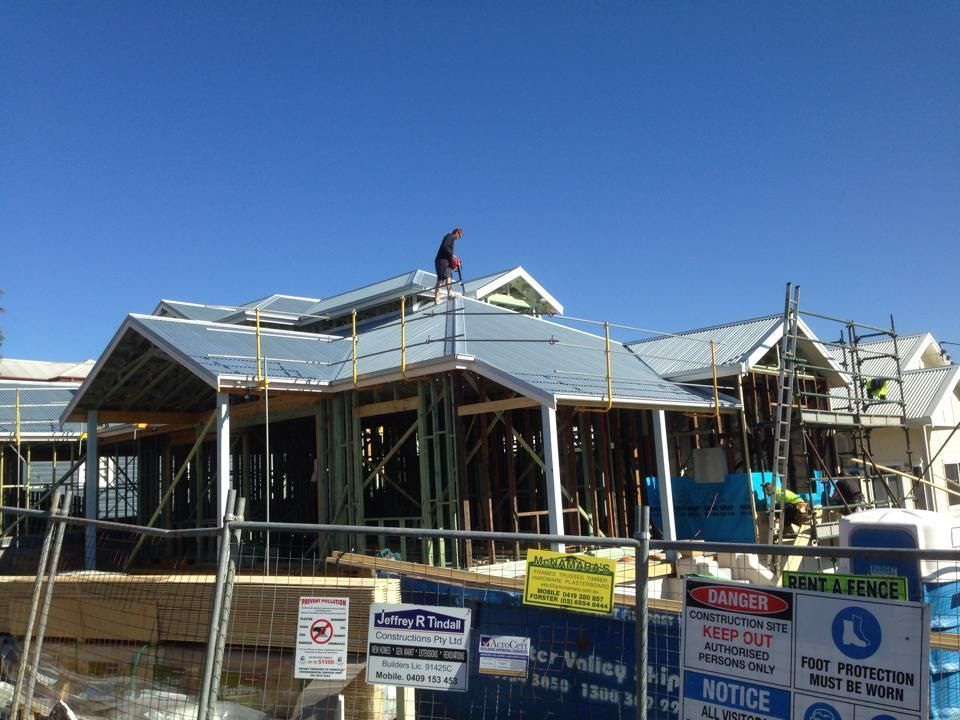 Man On Top Of The House Roof Under Construction — Mad About Metal Roofing & Guttering PTY LTD in Newcastle, NSW