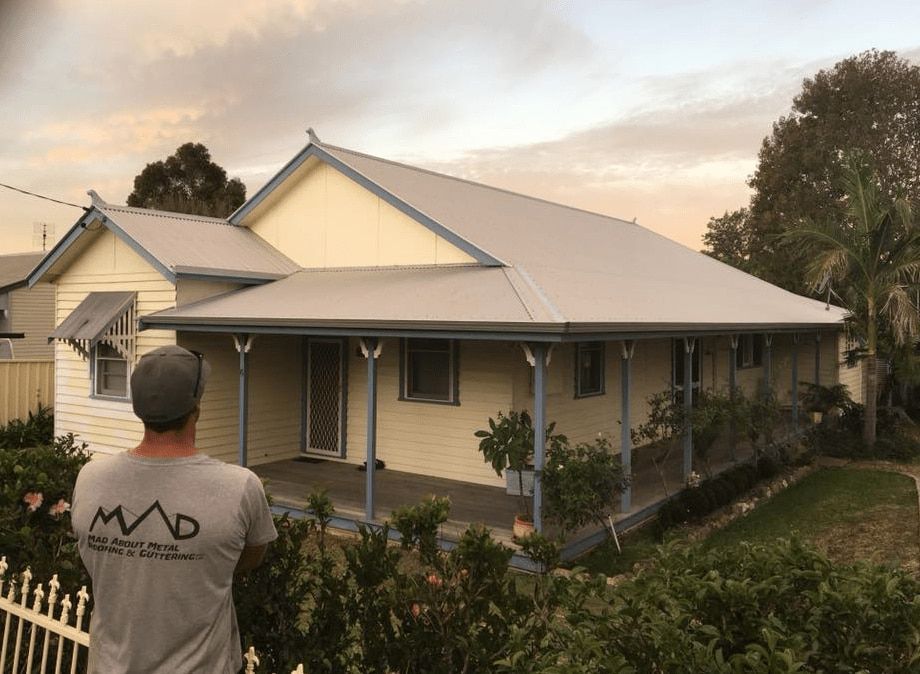 Man Looking At The Newly Installed Roof — Mad About Metal Roofing & Guttering PTY LTD in Newcastle, NSW