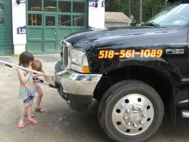 A black truck with the number 518-561-1089 on it