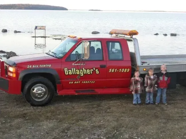 A red tow truck says gallagher 's on the side