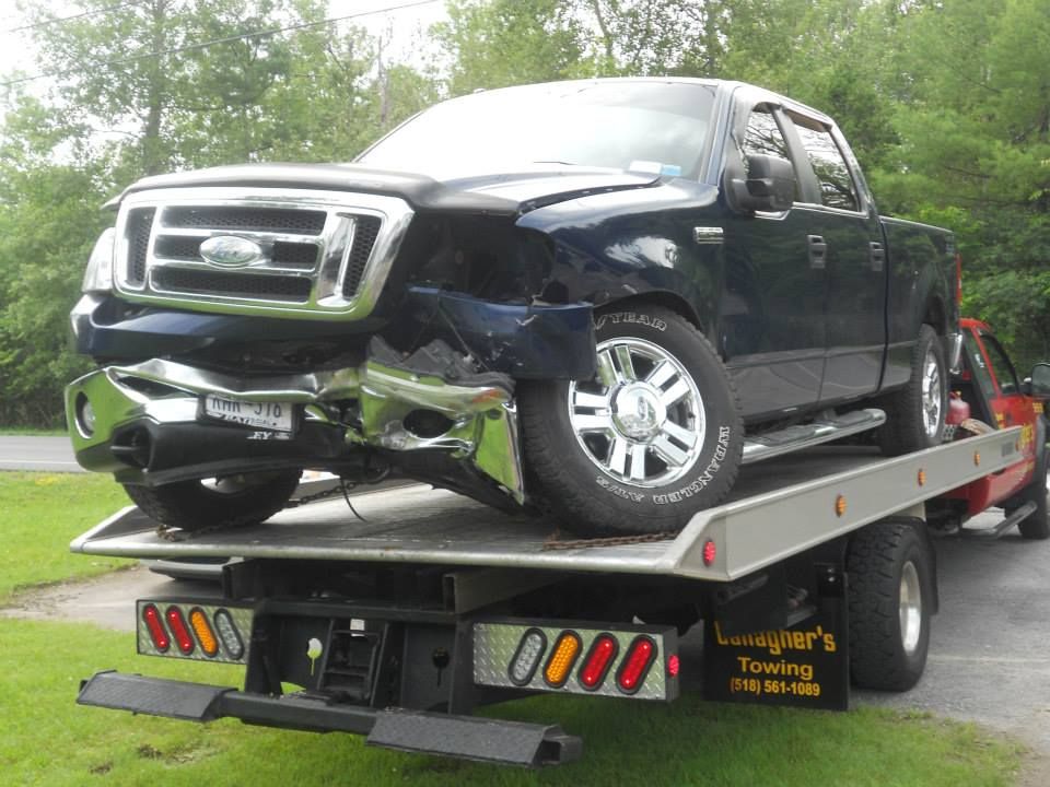 A ford truck is sitting on top of a tow truck