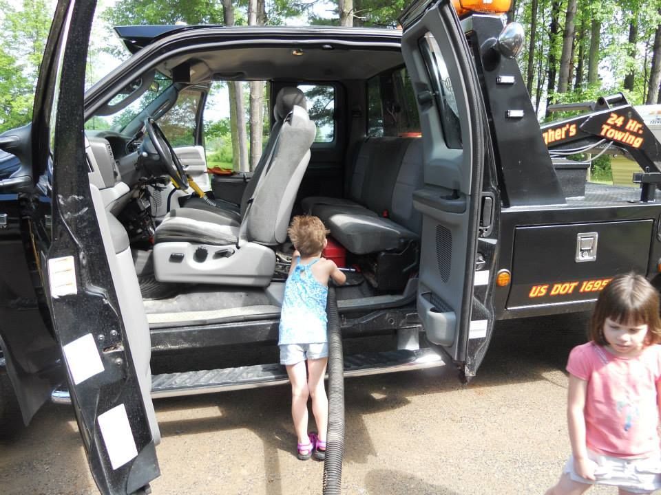 A little girl looking into the back of a tow truck