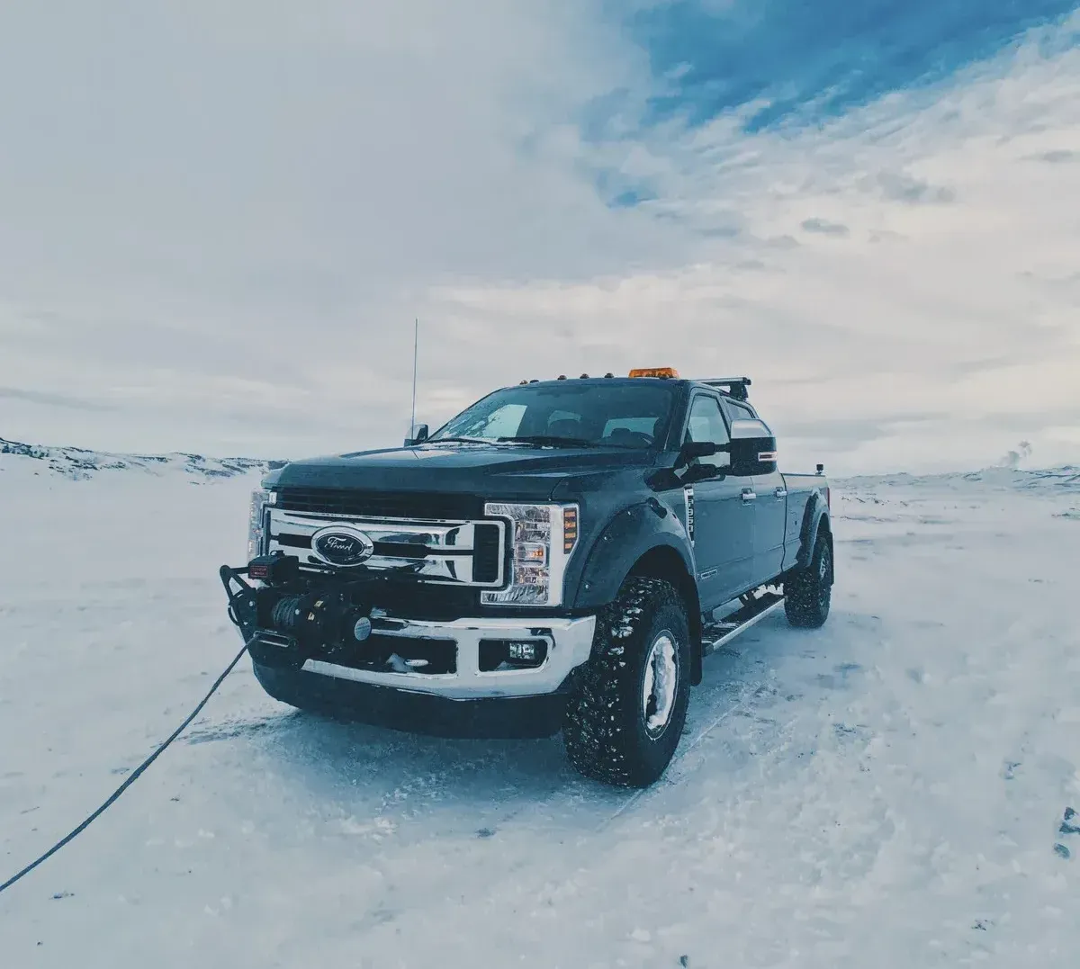 A black pickup truck is parked in the snow.