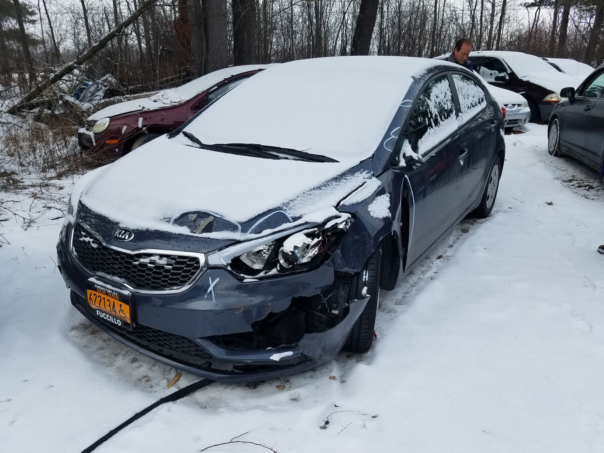 A car with a new york license plate is parked in the snow