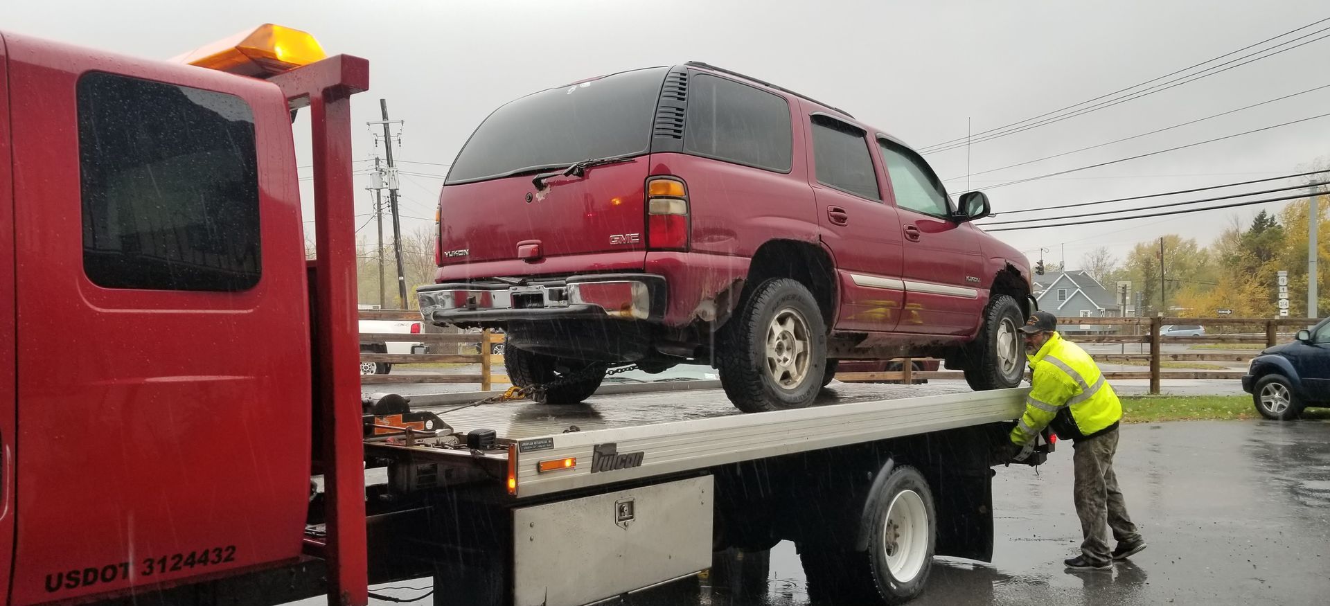 A red suv is being towed by a tow truck