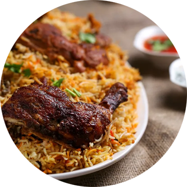Chicken biryani on a white plate, with a side of sauce.