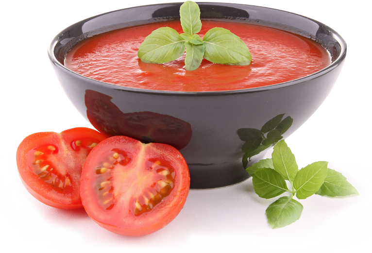 Bowl of tomato soup with basil, sliced tomatoes on the side.