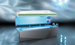 Tanning bed with blue UV lights and a white and grey exterior, in a bright setting.
