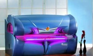 Blue tanning bed with pink lights; indoors.