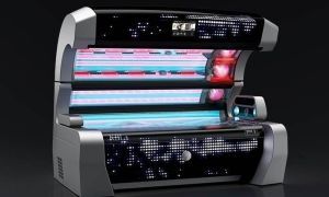 Tanning bed with a silver frame, blue and red lights, and control panel, against a dark background.