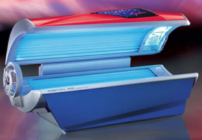 Tanning bed, blue and red with open lid and ultraviolet lights, interior setting.