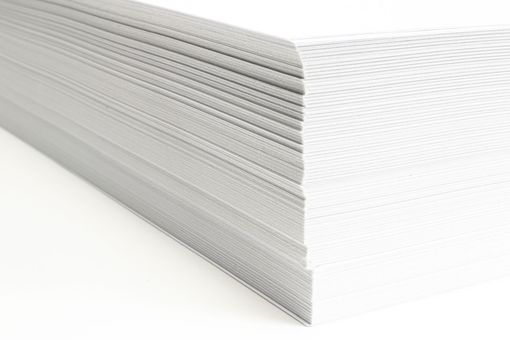 Un primer plano de una pila de toallas de papel blancas sobre una superficie blanca.