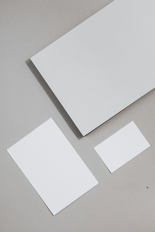 Una maqueta de una tarjeta de presentación, un sobre y una carta sobre una superficie gris.