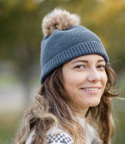 A close up of a woman wearing a hat and smiling.