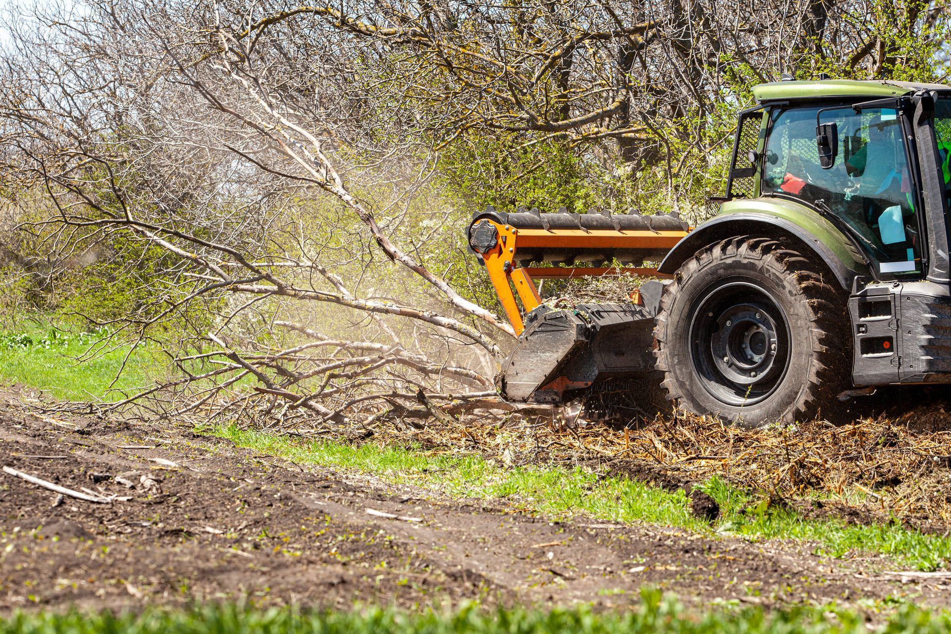 Picture of a tractor specialized in forest clearing that is in the process of destroying all the trees and bushes. Stop deforestation. Picture of a large tractor that destroys nature.