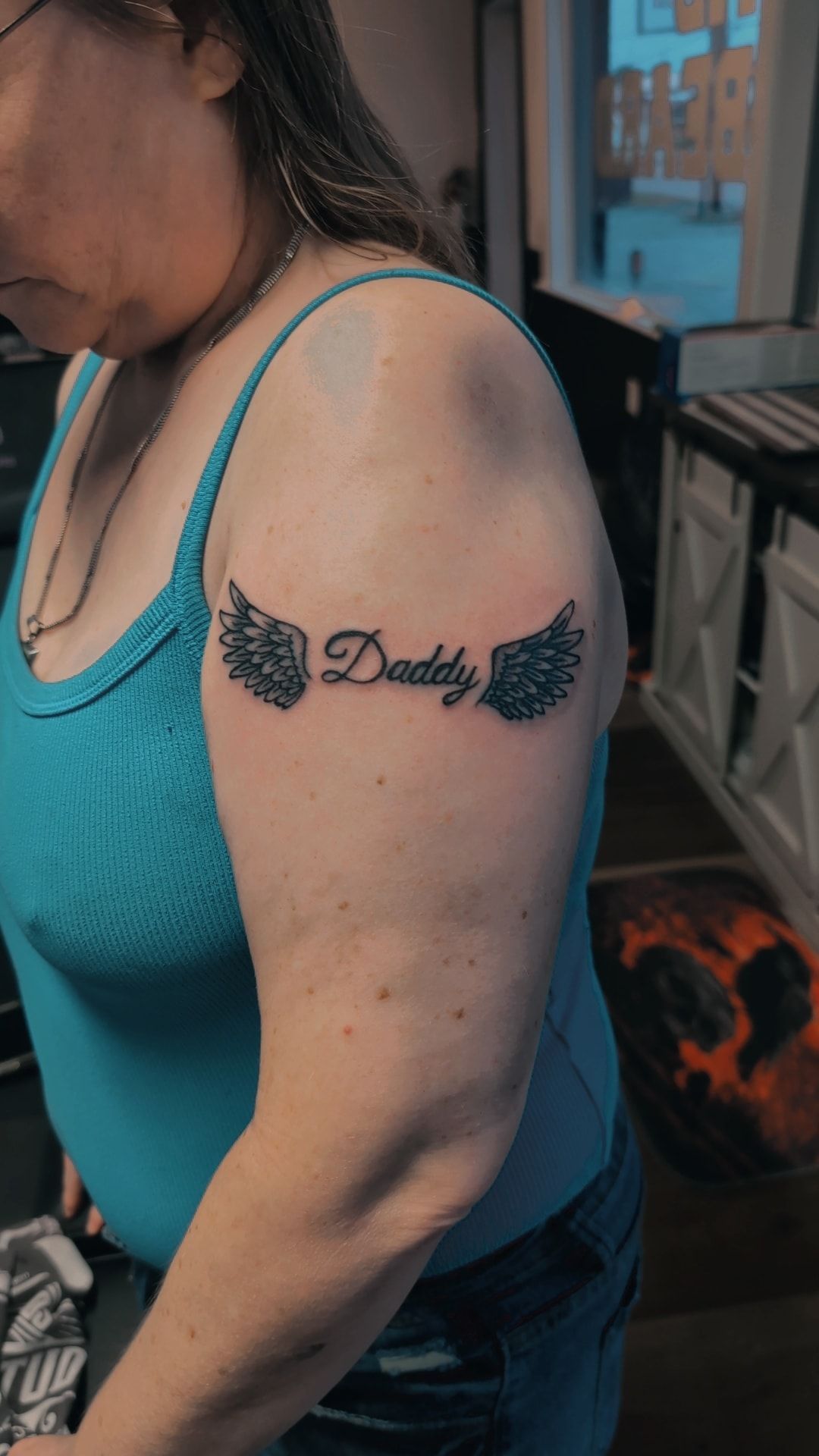 A woman has a tattoo on her arm that says `` daddy ''.