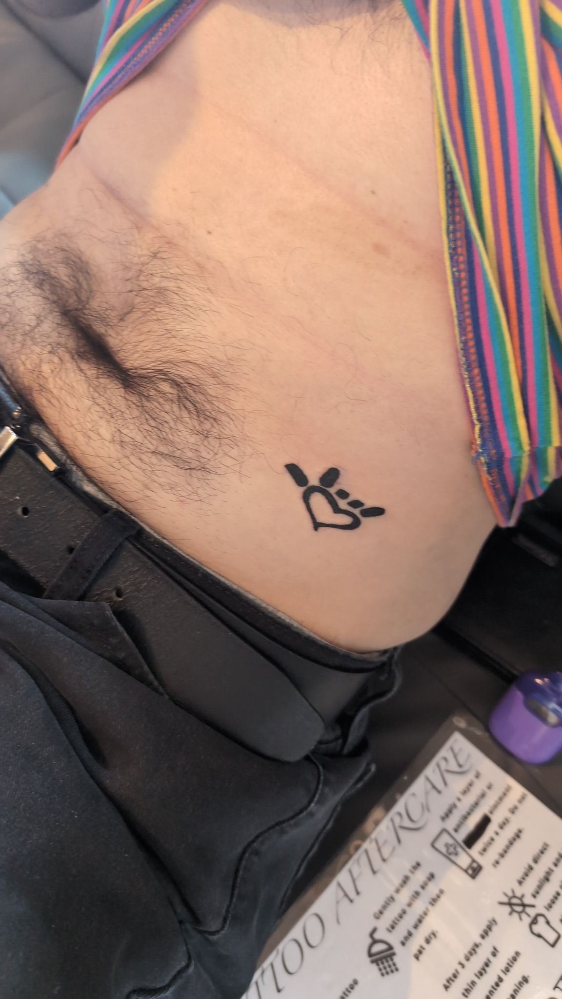A man has a small tattoo on his stomach