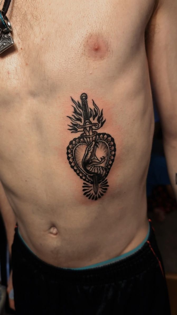 A man has a tattoo of a heart on his chest.