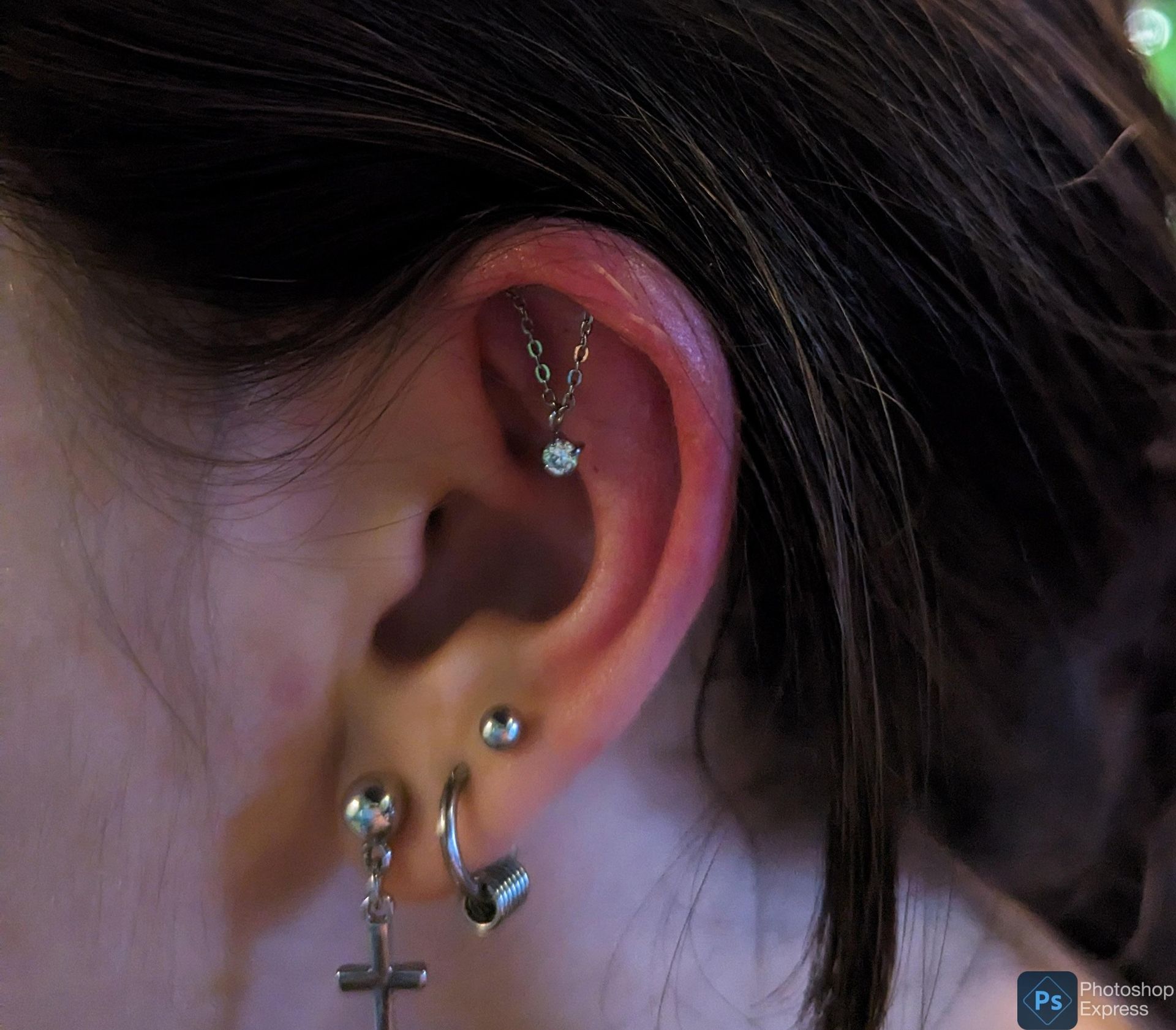 A close up of a woman 's ear with multiple piercings