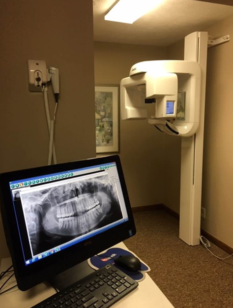 doctor checking patient teeth on computer