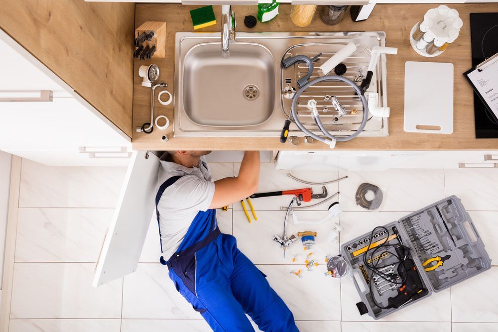 Skilled Plumber Expertly Repairing a Sink Pipe — CG Plumbing & Drainage In Maitland, NSW