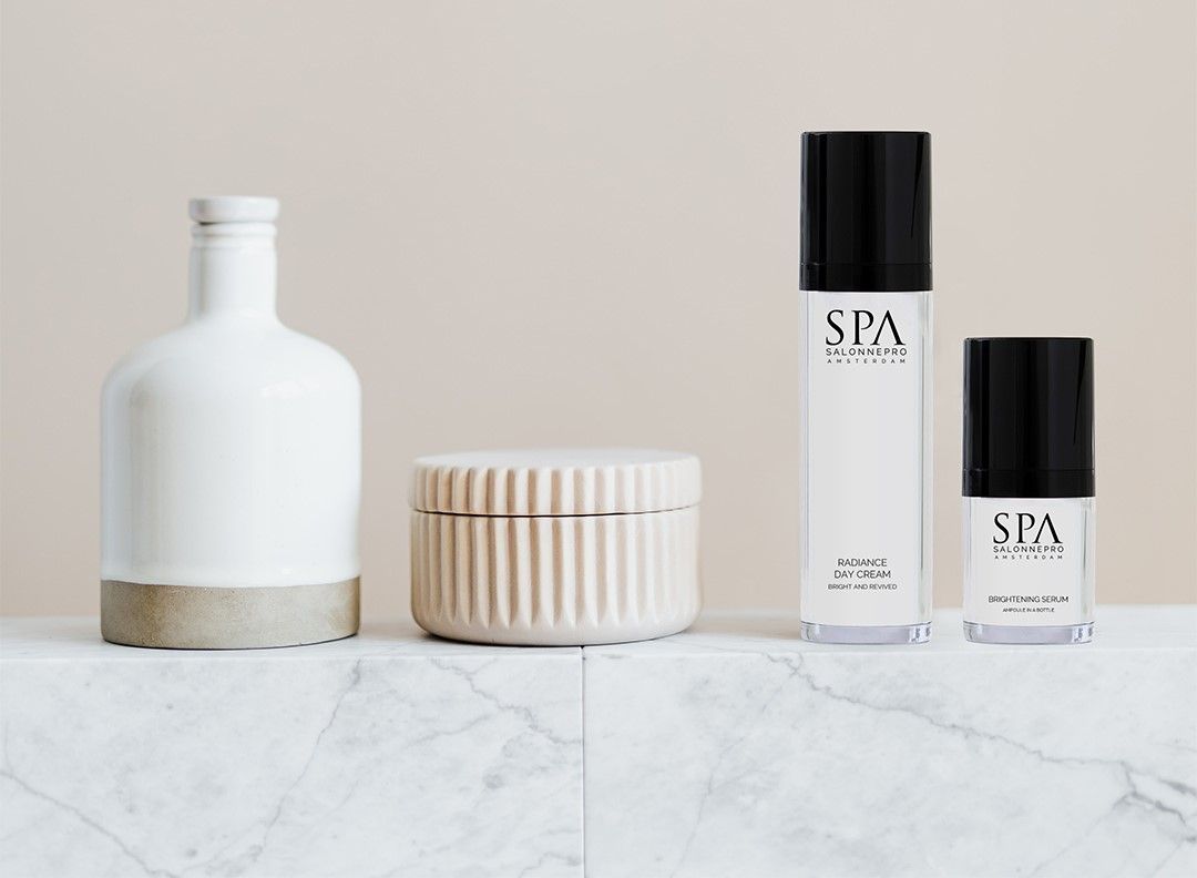 Twee skincare producten staan ​​op een marmeren plank.