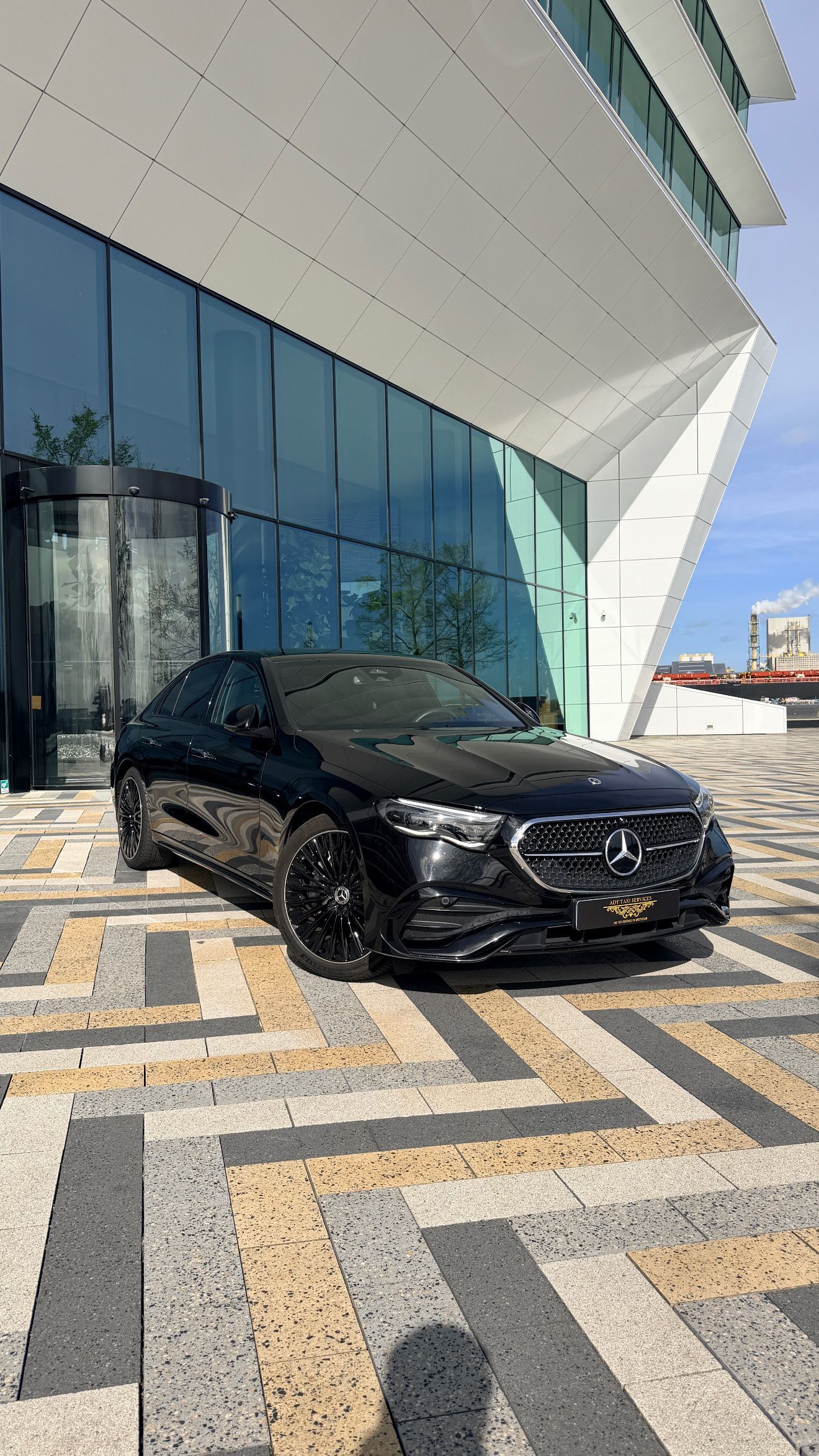 A black mercedes benz s class is parked in front of a building.